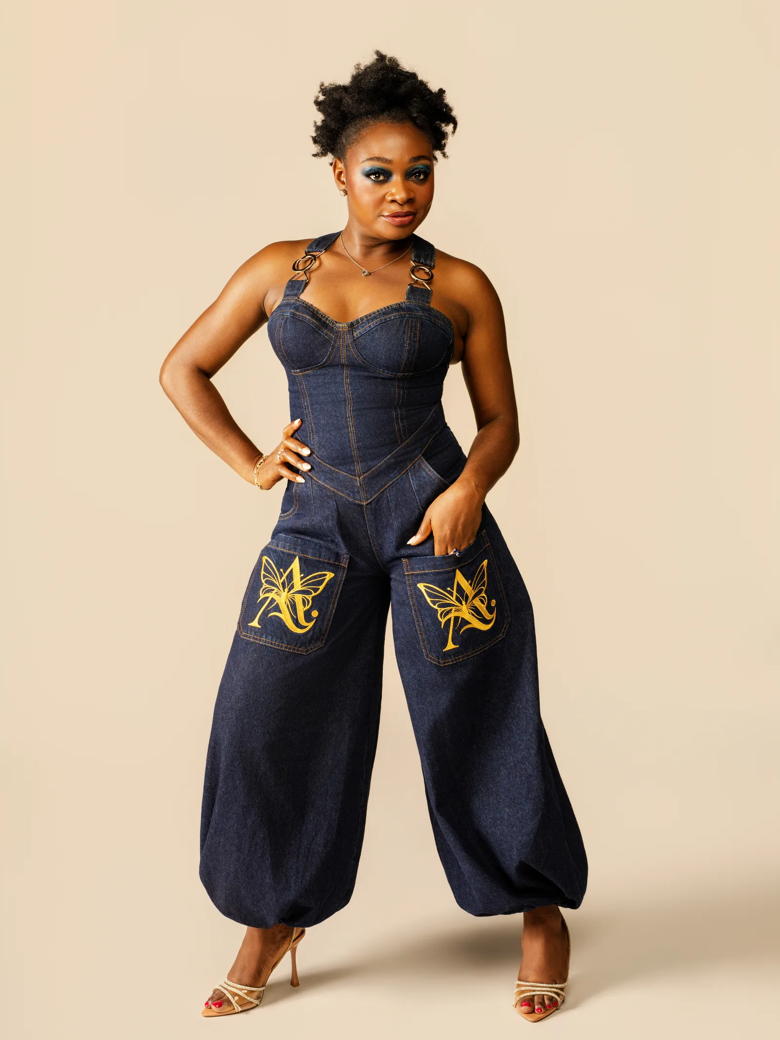 The Crisscross Jumpsuit from Collection 01, a dark denim corset jumpsuit with wide balloon legs and embroidered pockets, designed by Egoyibo Okoro